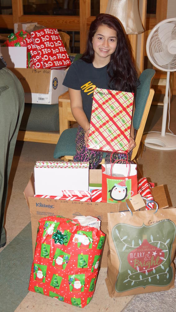Young brunette girl holding wrapped christmas presents