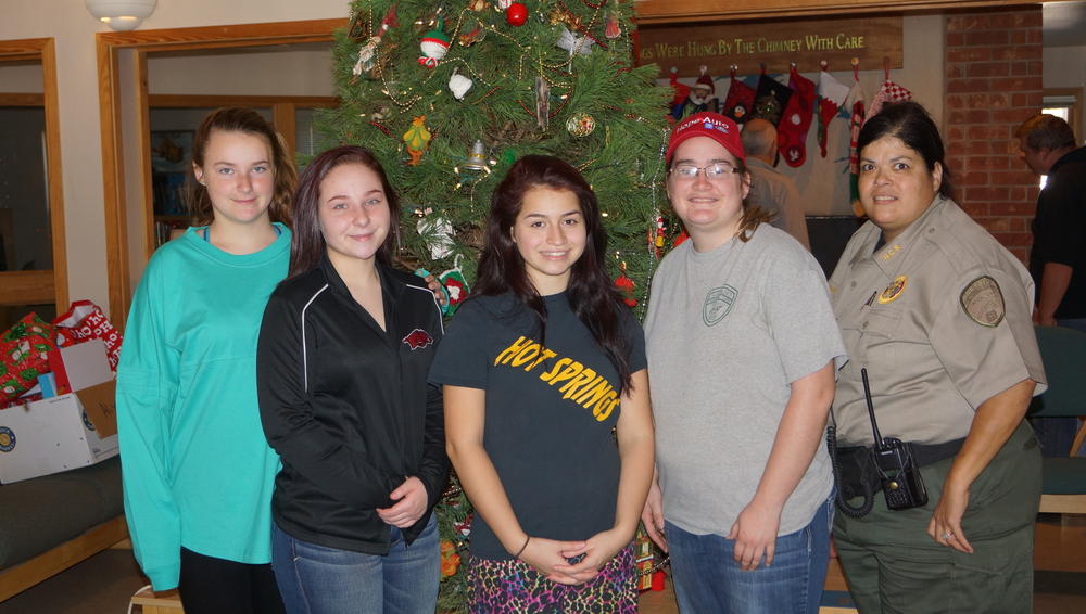 Five women standing in front of christmas tree smiling