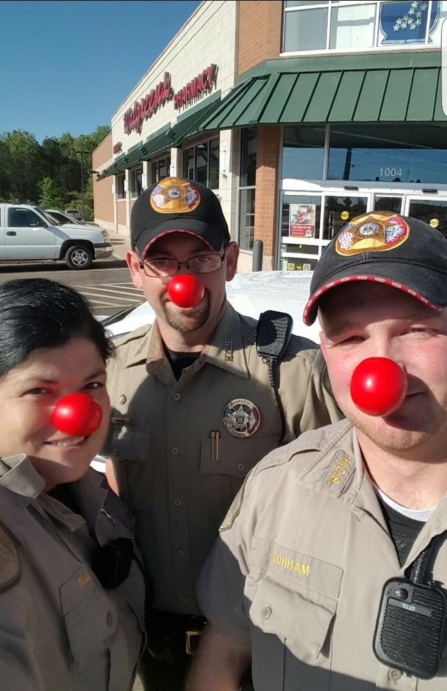 3 officers wearing red noses