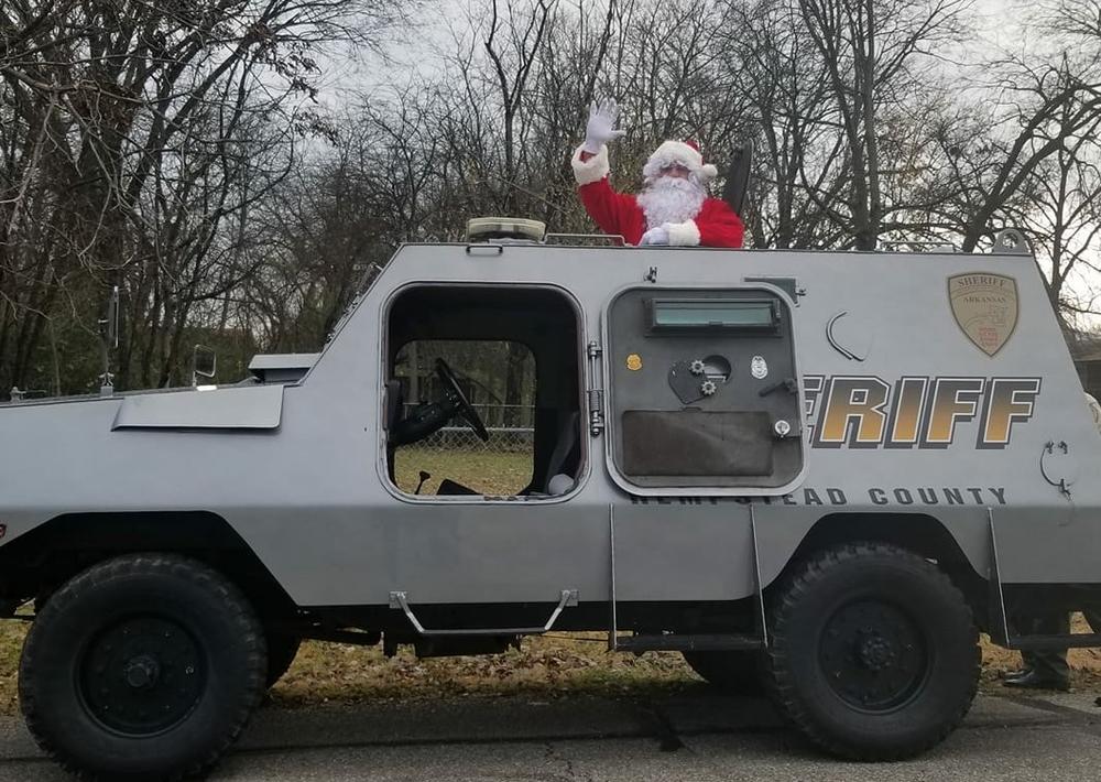 Santa standing out of a sheriff vehicle