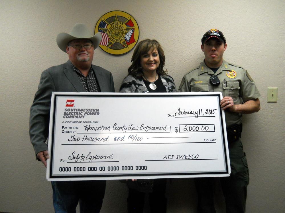 3 people standing holding a giant check for $2000