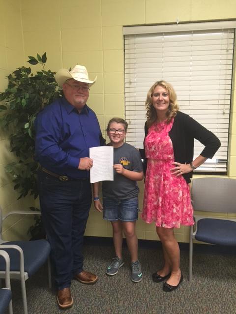 Sheriff Singleton, Darci, and woman standing with Darci's handwritten letter