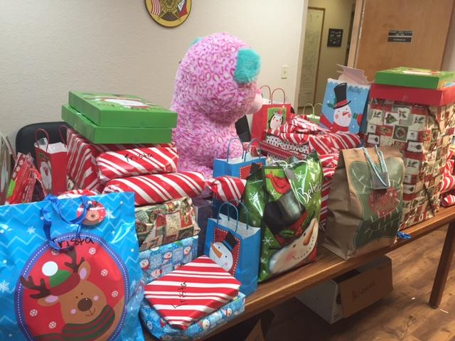 Large stack of christmas presents on table