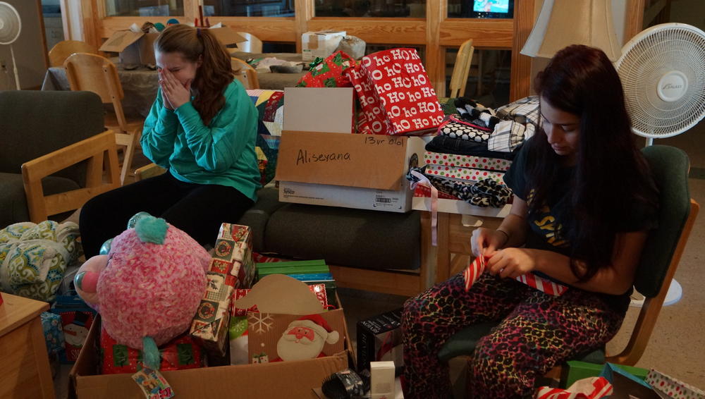 Two girls opening christmas presents