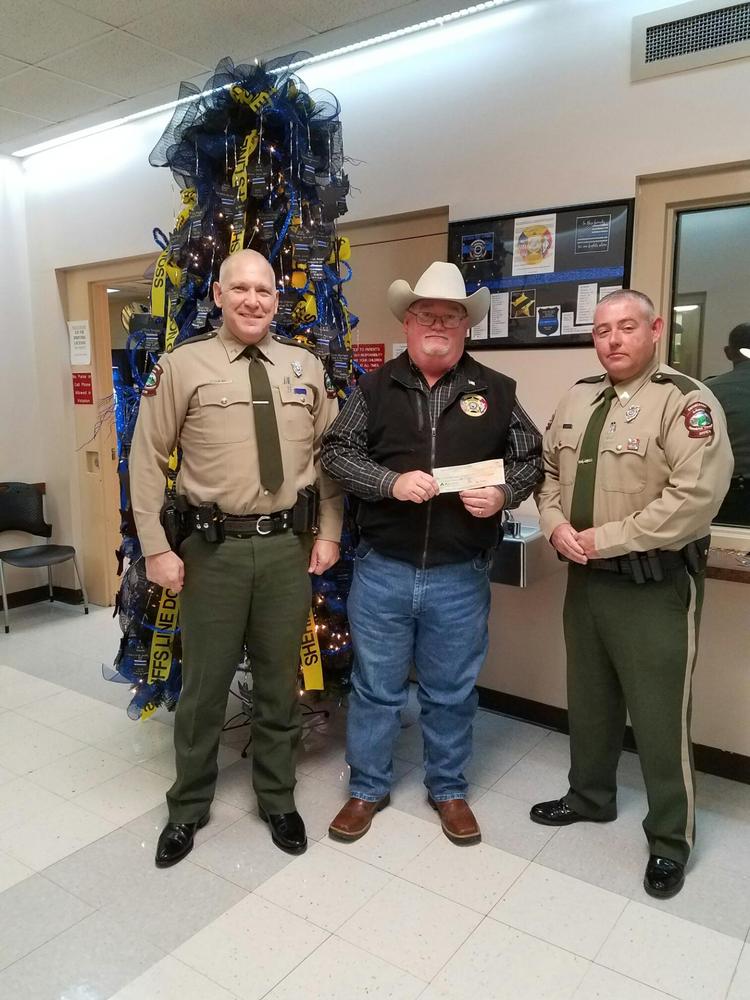 Enforcement Officers Dennis Hovater and Jeff Neel present a $500.00 dollar check from the Arkansas Wildlife Officers Association to Sheriff James Singleton