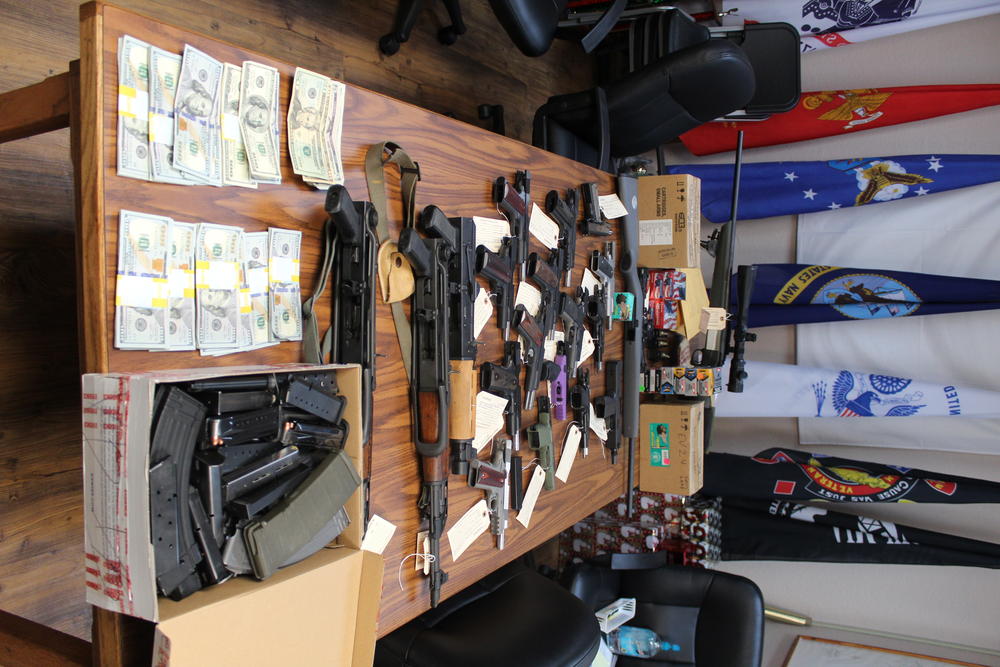 firearms and money stacks laying on a table