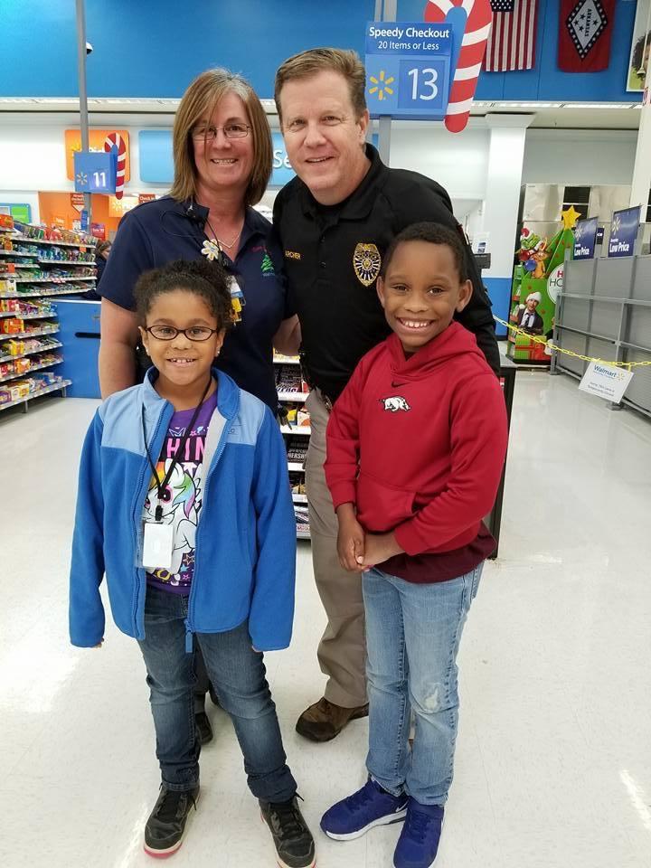 Two adults and two children standing and smiling