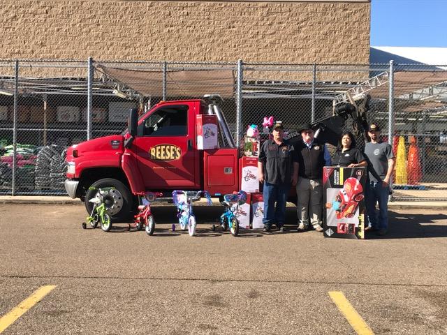 Sheriff's Office staff and Gary Reese in front of Reese's Wrecker truck with toys