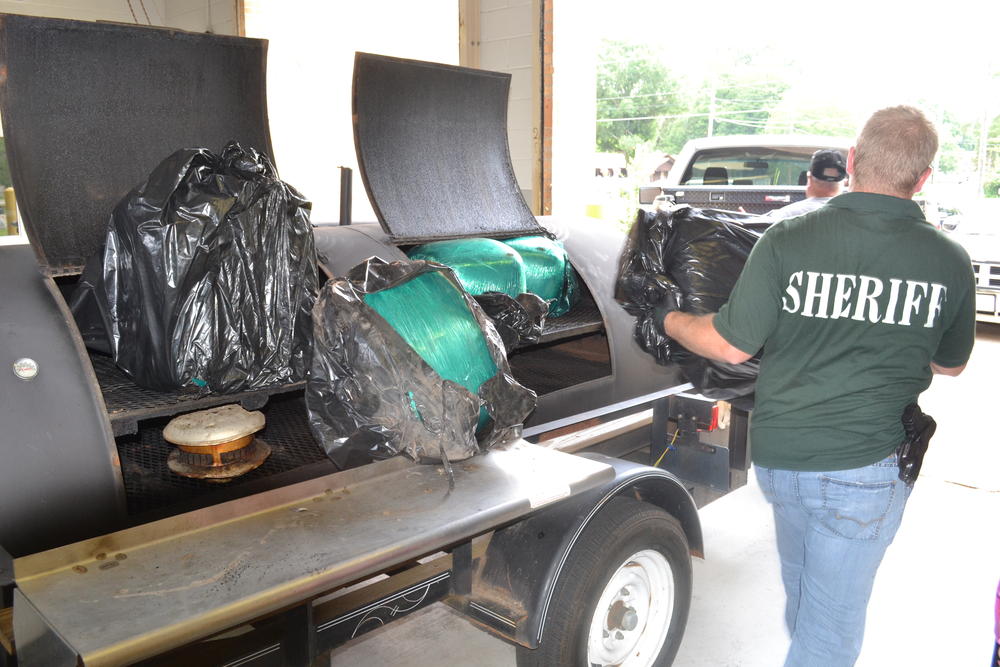 Officers carrying away Marijuana found in grill