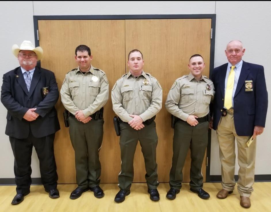 3 deputies standing in uniform, with Sheriff and another man in a suit