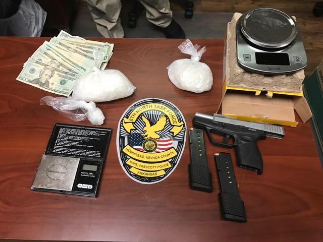 weapons, money, and bags of drugs on a table
