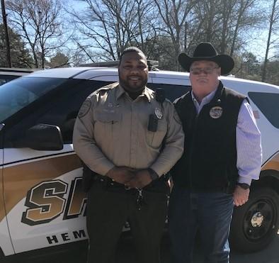 Orlando Dennis and Sheriff Singleton standing in front of patrol car