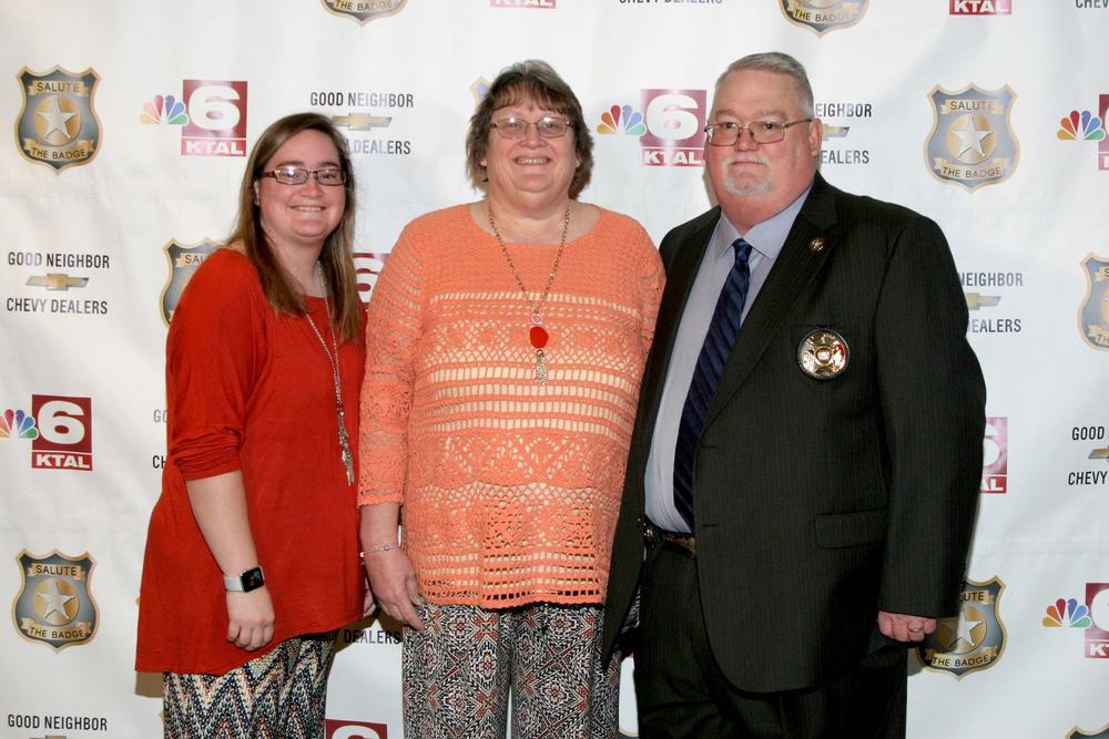 Sheriff Singleton standing with 2 women in front of backdrop