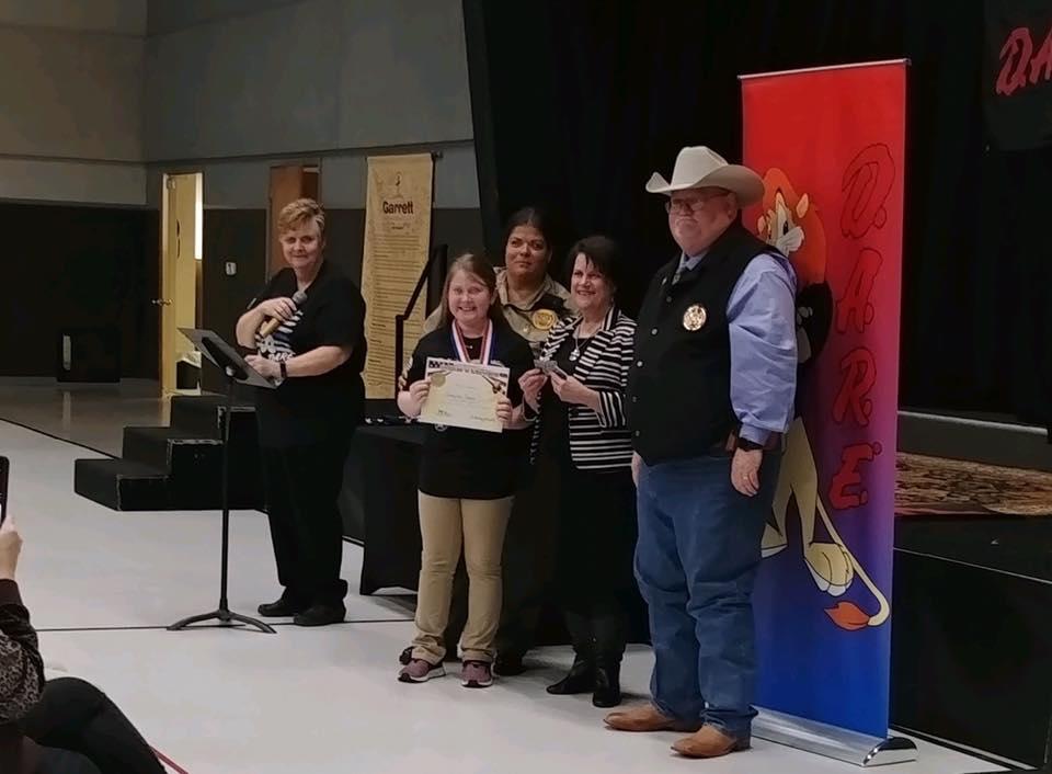 Sheriff's Office staff with DARE student holding award