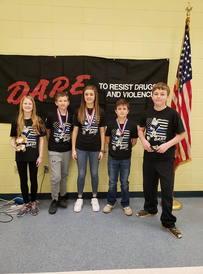 5 DARE students standing in front of DARE sign