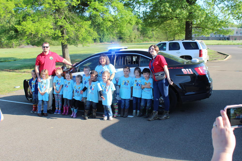 GMCS students with sheriff's office staff in front of patrol vehicle